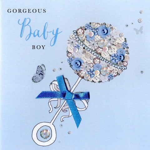 alt=“Baby Boy Rattle quality hand-finished, blue button, sequin and glitter embellished greeting card sealed in a protective wrapping complete with envelope. Message: Gorgeous Baby Boy. Wishing you a world of happiness with your new arrival”