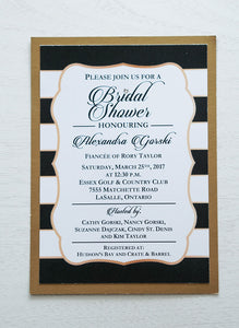 alt="Modern Bridal Shower invitation features a matte white stock on an antique gold pearlescent shimmer stock, a black and white striped background with a gold frame, a bold script font and a jewel detail to finish it off"