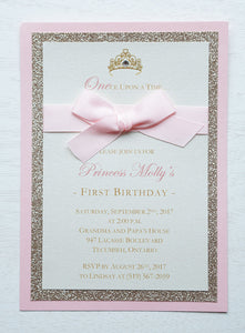 alt="Classic birthday party invitation features an ivory pearlescent shimmer stock on rose gold glitter and pink pearlescent shimmer card stock layers, an elegant gold crown and jewel detail and is finished together with a rich pink ribbon bow"