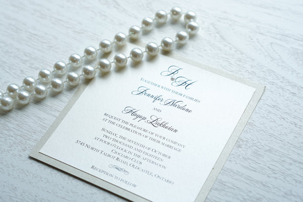 alt="Classic square wedding invitation features an ivory pearlescent shimmer card stock on a champagne gold pearlescent shimmer stock, black font and a monogram/pearl detail"