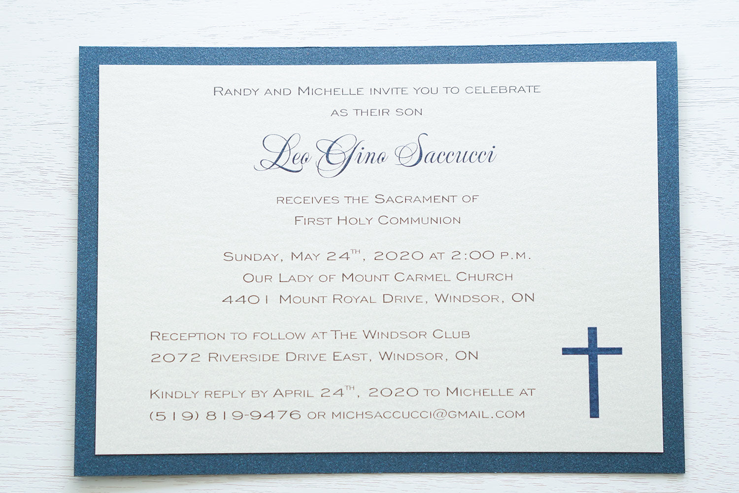 alt=“Classic First Communion invitation features a white pearlescent shimmer card stock on a blue pearlescent shimmer card stock finished with a simple blue cross detail”