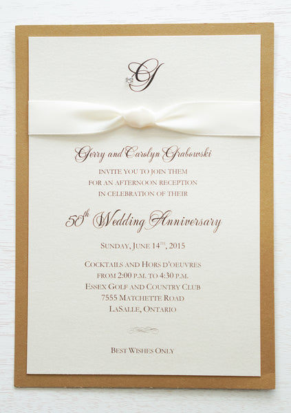alt=“Classic 50th Wedding Anniversary invitation features an ivory pearlescent shimmer card stock on a gold leaf pearlescent shimmer card stock, an elegant monogram and jewel detail and is finished with a rich ivory knotted ribbon”