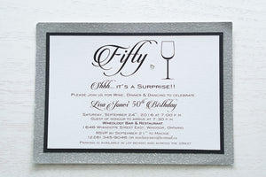 alt="Modern birthday invitation features a white pearlescent shimmer card stock on matte black and silver glitter card stock, a fun wine glass image, fifty written in script and is finished with a jewel detail"