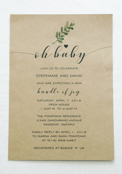 alt=“Simple rustic gender neutral baby shower invitation features kraft card stock with a greenery detail and an “Oh Baby” sentiment with heart”