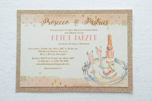 alt="Glam glitter Bridal Shower invitation features an ivory pearlescent shimmer card stock on a rose gold glitter stock, an elegant blush pink watercolour border, a prosecco and macaron design and jewel detail to finish it off"