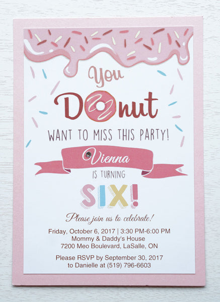 alt="Sweet donut birthday party invitation features a matte white stock on a pink pearlescent shimmer card stock, a donut and sprinkle design and is finished with a jewel detail"
