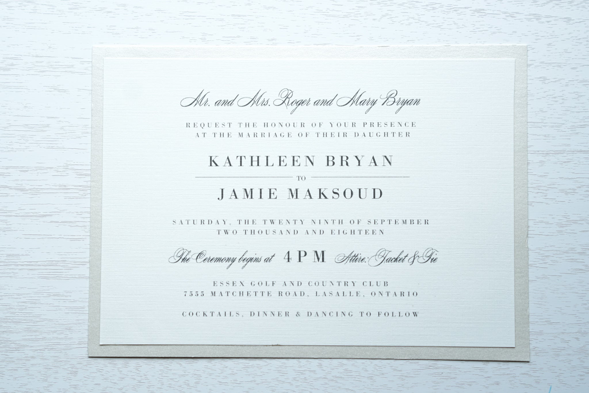 alt="Classic wedding invitation features an ivory linen matte card stock on an ivory pearlescent shimmer stock layer, charcoal grey font and an elegant typography design"