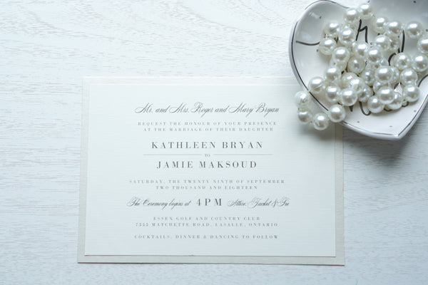 alt="Classic wedding invitation features an ivory linen matte card stock on an ivory pearlescent shimmer stock layer, charcoal grey font and an elegant typography design"