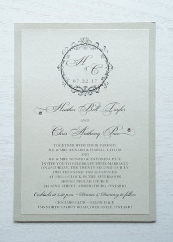 alt="Timeless wedding invitation features an ivory pearlescent shimmer card stock on a champagne gold pearlescent shimmer stock, an elegant script font and a round frame design with a monogram/jewel detail"