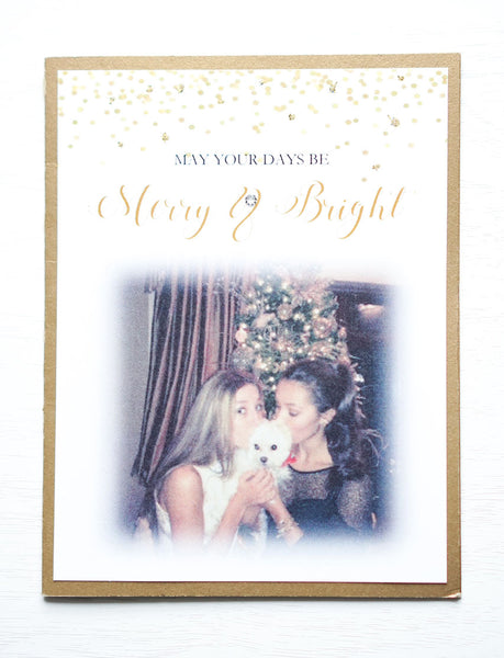 alt="This modern photo card features a white matte and antique gold pearlescent shimmer card stock, gold glitter and confetti detail at top with “May your days be Merry & Bright” printed below in gold and black writing and a photo of your choice"