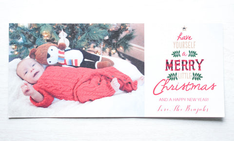 alt="This festive photo card features a white pearlescent card stock, “Have yourself a Mery Little Chirstmas and a Happy New Year” printed tree pattern with buffalo plaid and jewel detail as well as a photo of your choice"