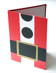alt="This jolly card resembles Santa’s suit and features red pearlescent shimmer card stock with black matte card stock for the belt and buttons, gold glitter card stock for the buckle and white matte card stock for the fur"