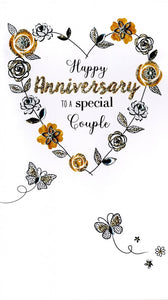 alt=“Anniversary quality hand-finished, gold glitter embellished greeting card with flowers and butterflies sealed in a protective wrapping complete with envelope. Message: Happy Anniversary to a special Couple. Wishing you many more years of happiness together”