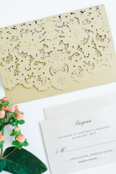 alt="Graceful gold pearlescent shimmer laser cut  pocket wedding invitation features an ivory pearlescent shimmer stock on a black matte stock insert and is finished with jewel details"